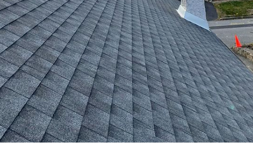 Roofer removing shingles for a roof replacement